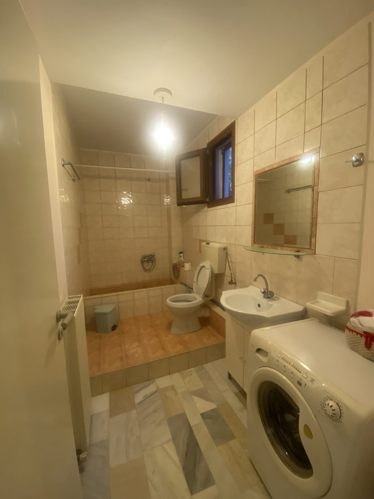 Garden-level apartment bathroom with washing machine