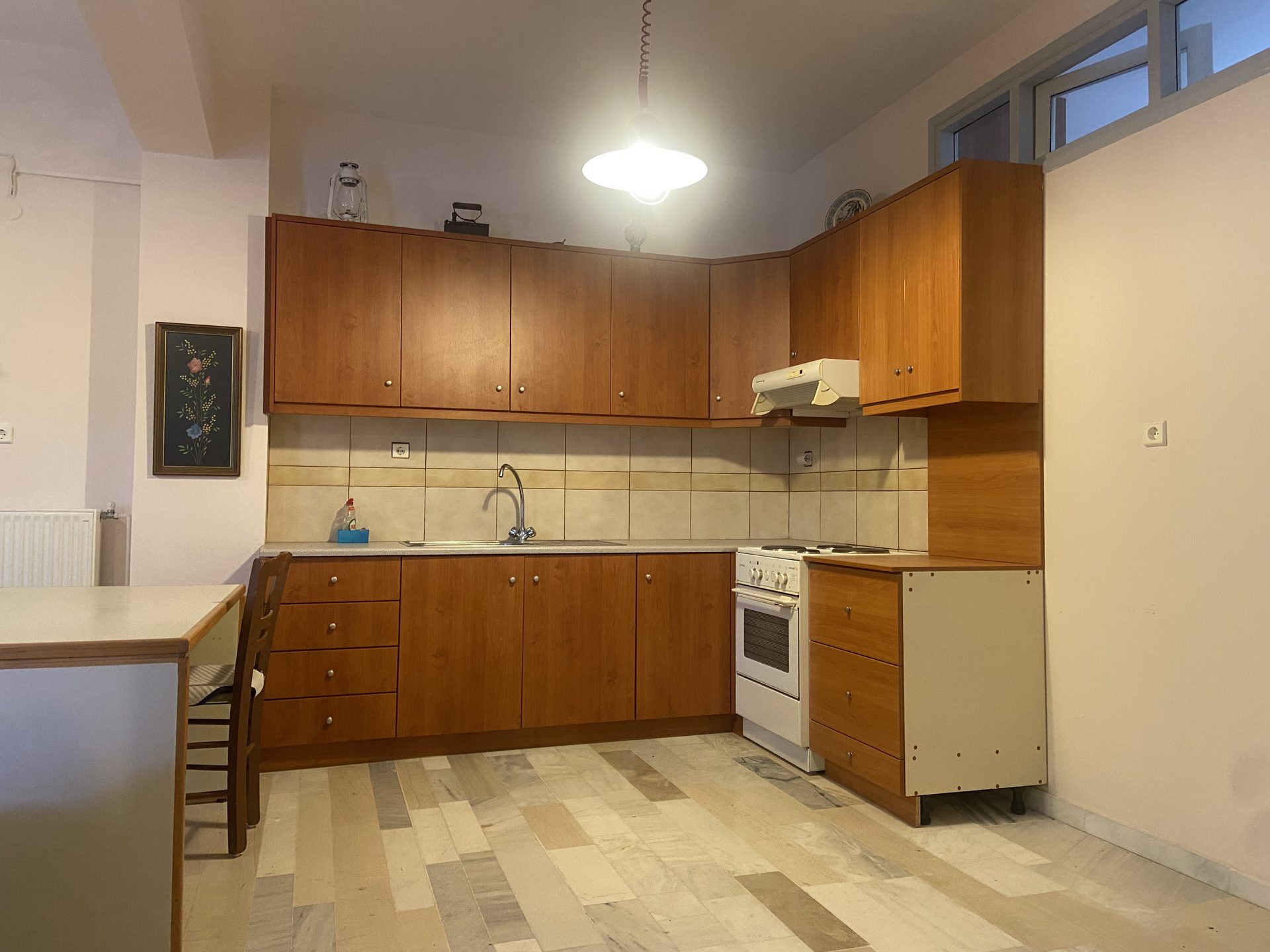 Garden-level apartment kitchen with wood cabinetry and dining area