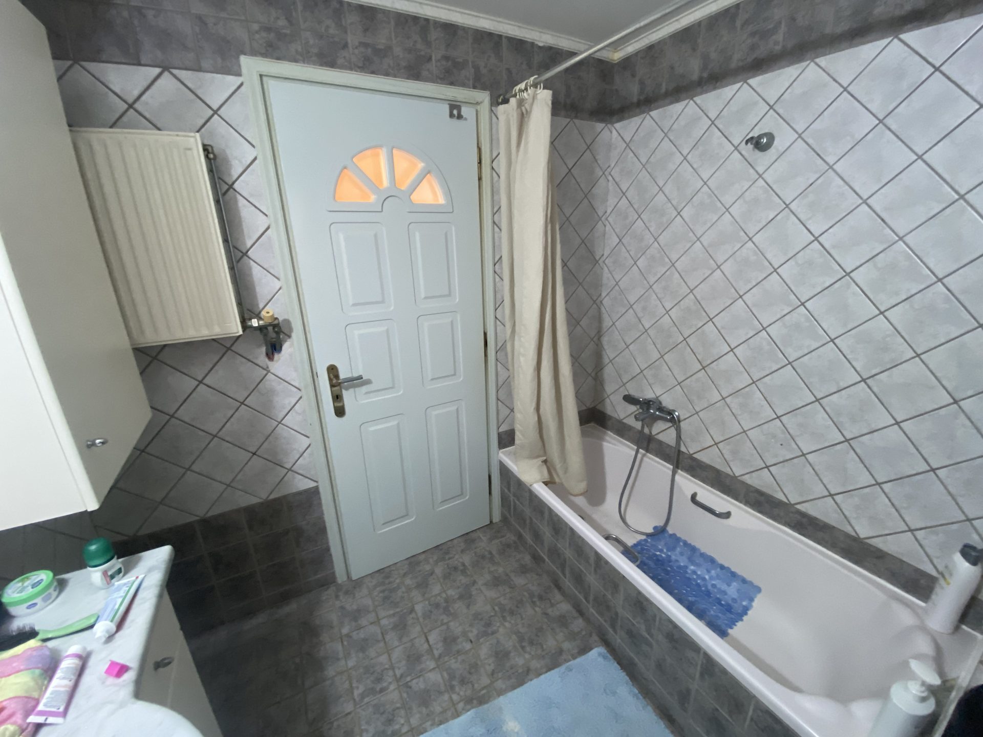 Main bathroom with tiled walls and full-size bathtub