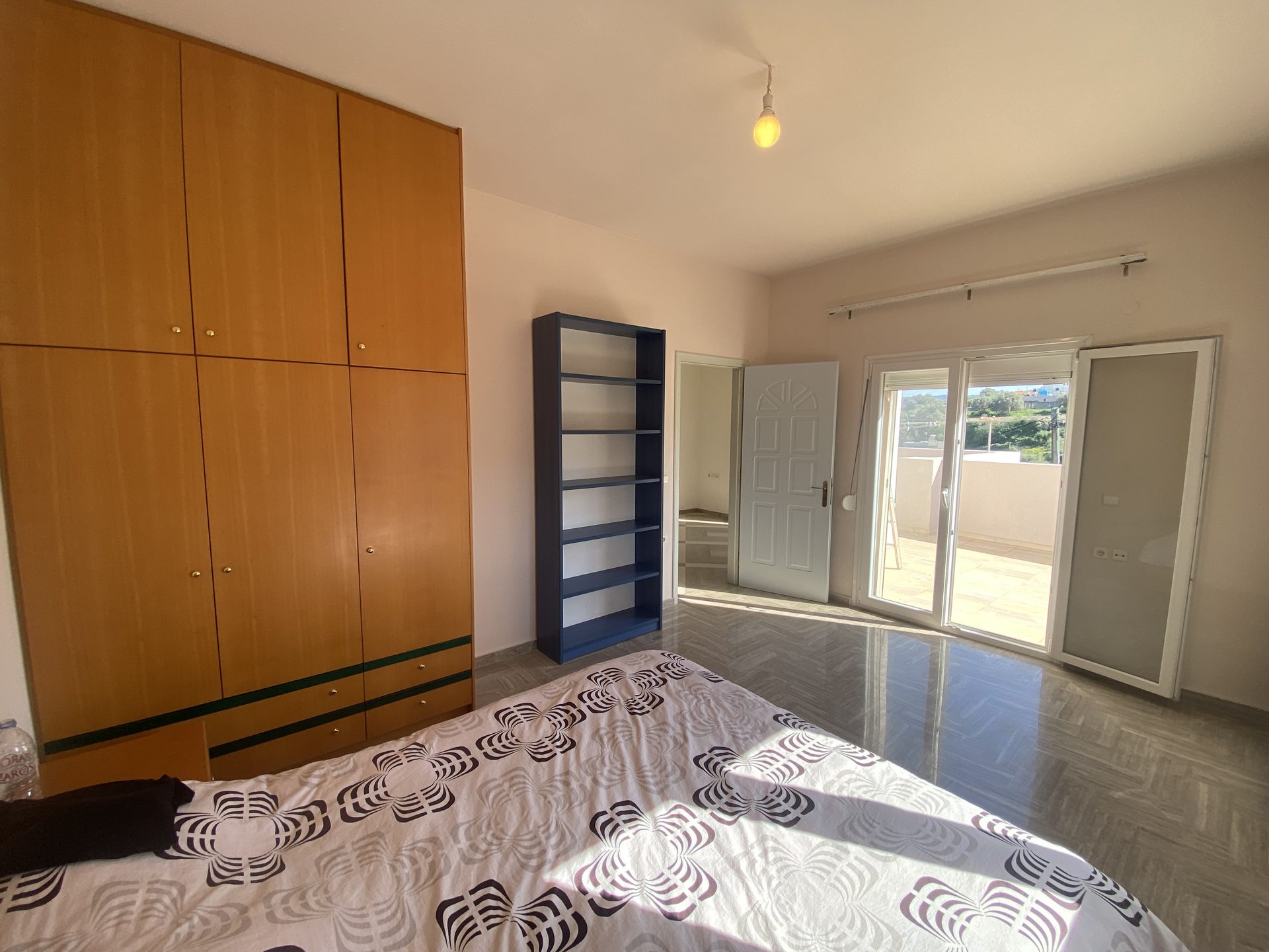 Bedroom with built-in bookshelves, wardrobe, and French doors to balcony
