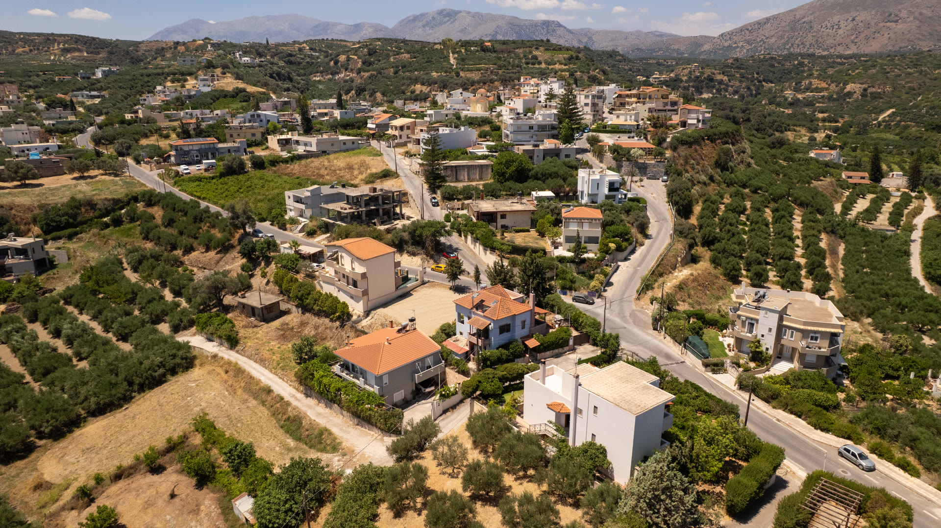Aerial view of Kavrochori village, the property setting, and the mountain backdrop