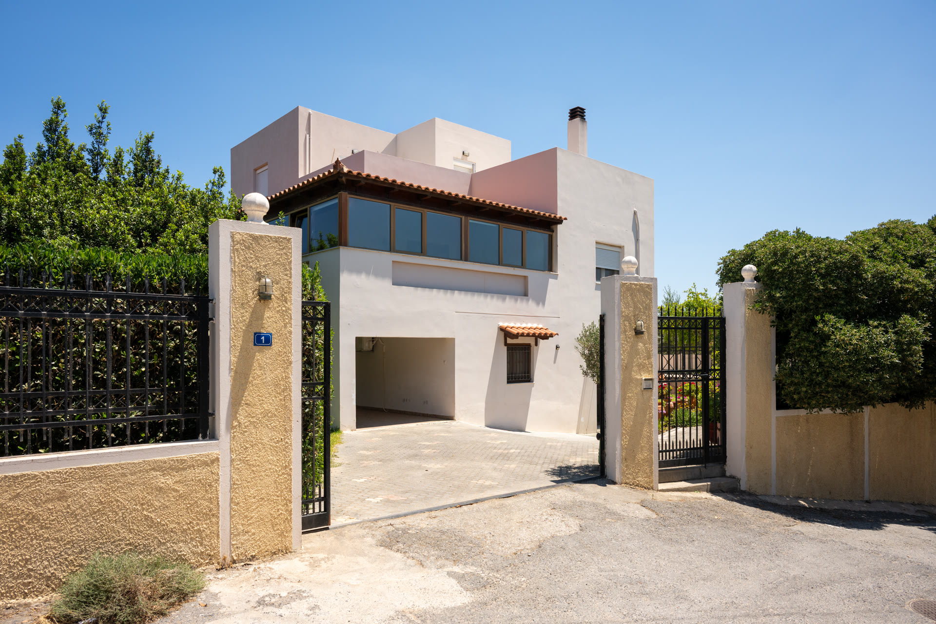 Gated entrance and paved driveway leading to the two-story house