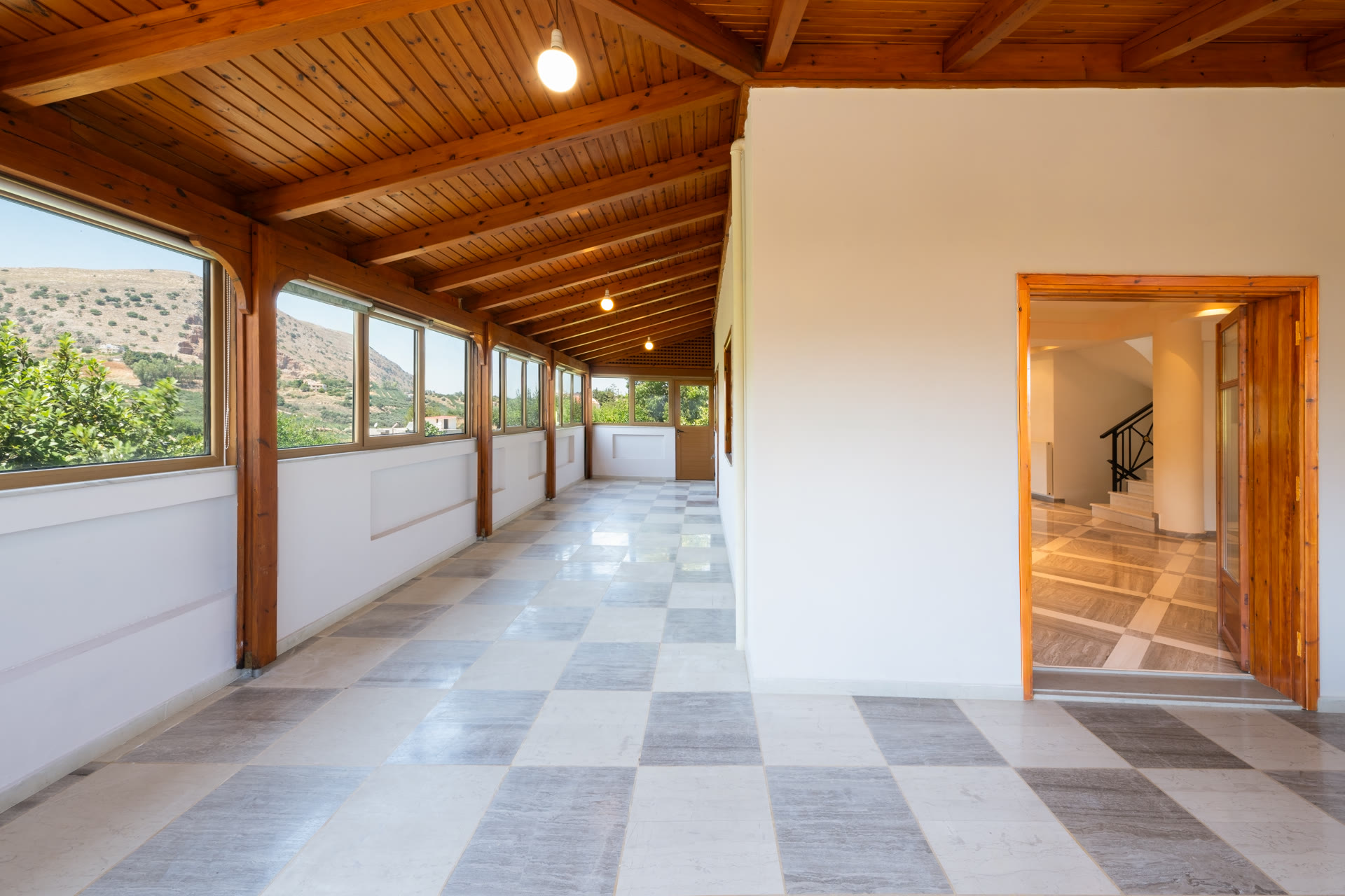 Long enclosed terrace with timber ceiling, mountain views, and direct access to the main living area