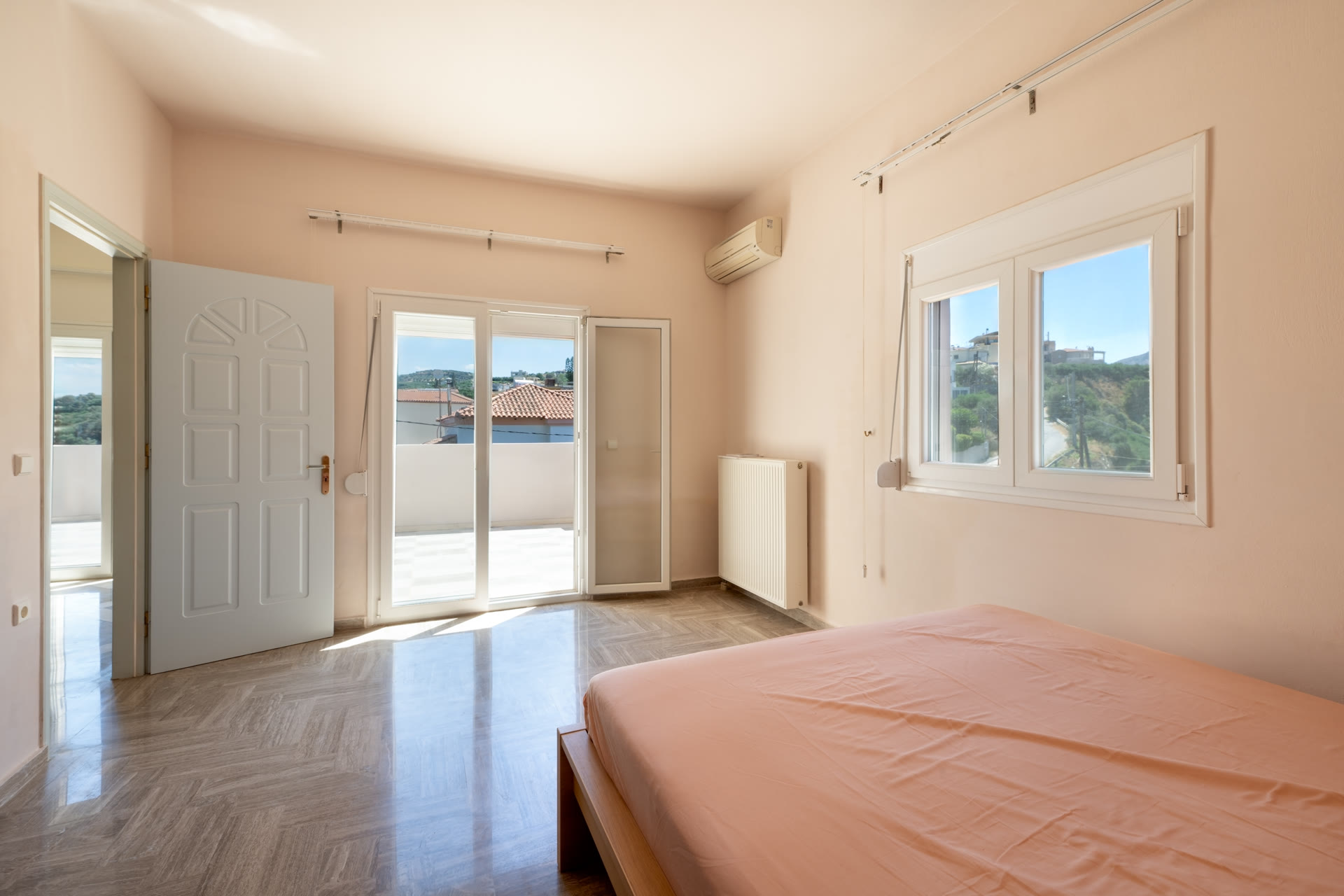 Bedroom with bed, balcony door, window, air conditioning, and countryside outlook