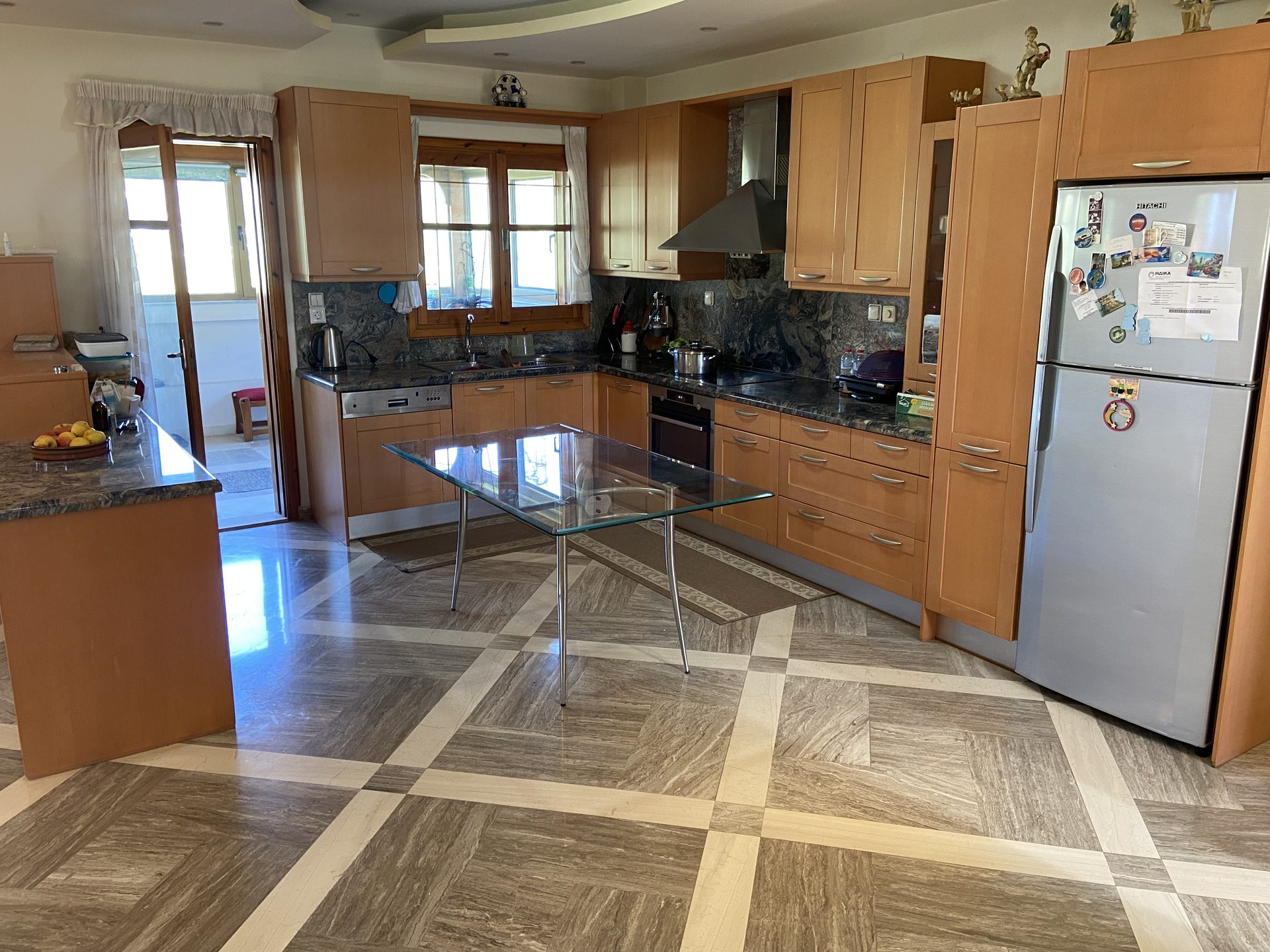 Kitchen with solid wood cabinetry, granite countertops, and glass dining table