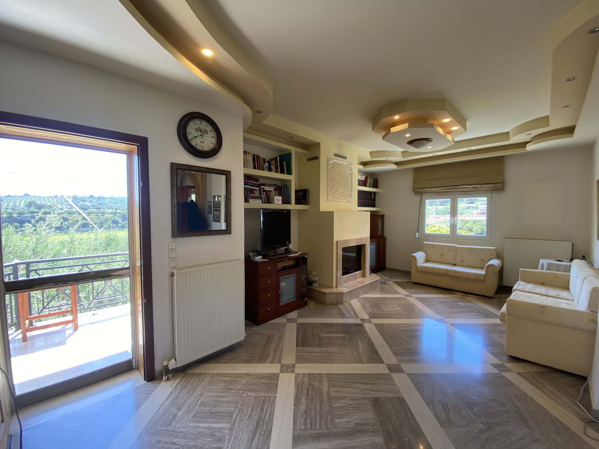 Spacious living room with fireplace and panoramic olive grove view