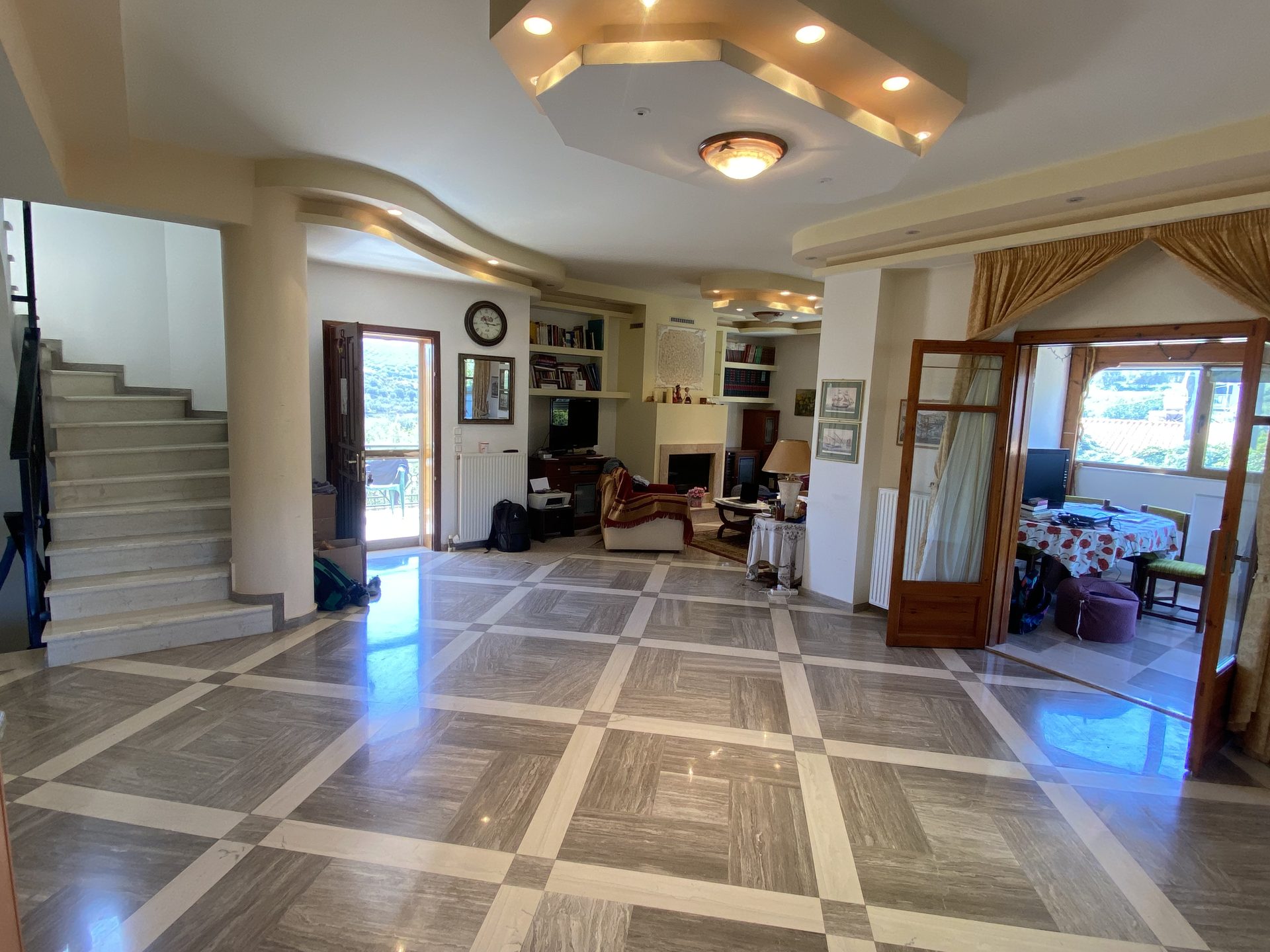 Open-plan central hall with marble staircase and fireplace seating