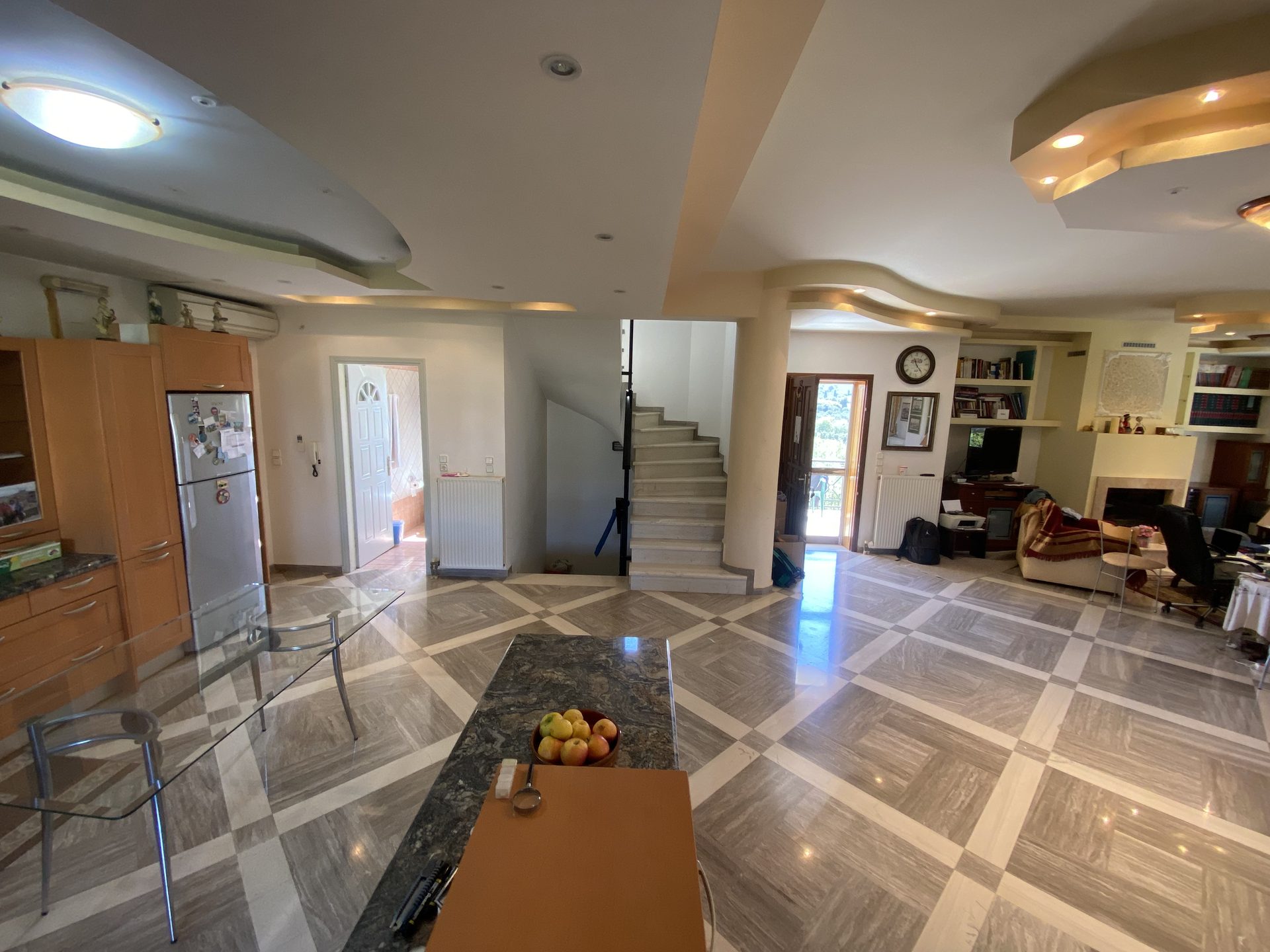 Central hall viewed from kitchen peninsula, with fireplace and marble staircase